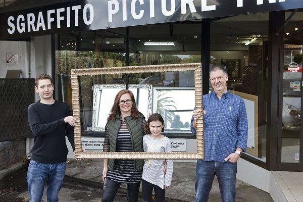 Stu Robb and his family standing outside the Sgraffito Picture Framers workshop on Garden Road